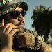 DJ Pumba, Snow Tha Product's main producer and tour DJ, wearing sunglasses and a bucket hat in front of palm trees in Los Angeles