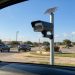 License plate reader camera with solar panel on a pole beside a Dallas area street